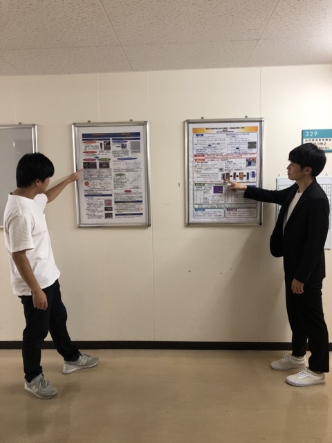 発表しているイメージで２人で記念撮影。<br>２人のポスターは廊下に展示されています。
